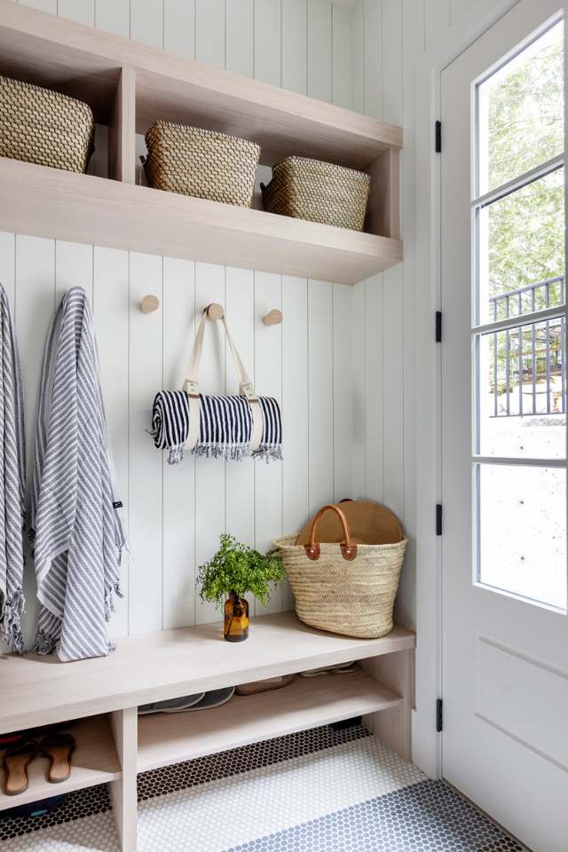 entryway with blue and white penny tile, wooden bench and shiplap walls